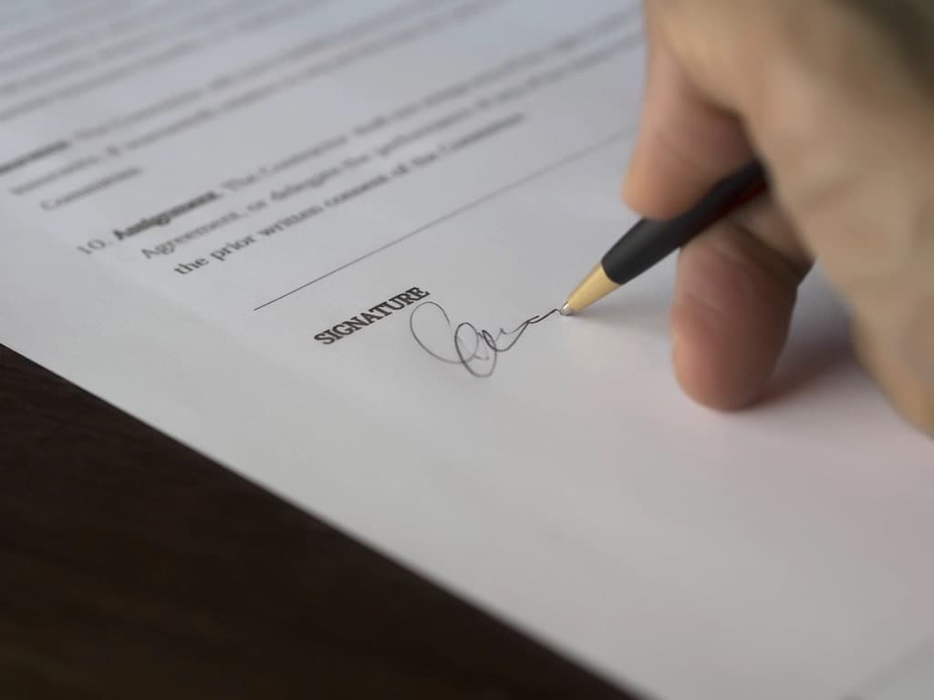 Hand signing a mortgage document with a pen