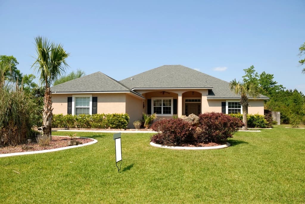 Single-story Jacksonville home with palm trees and a green lawn